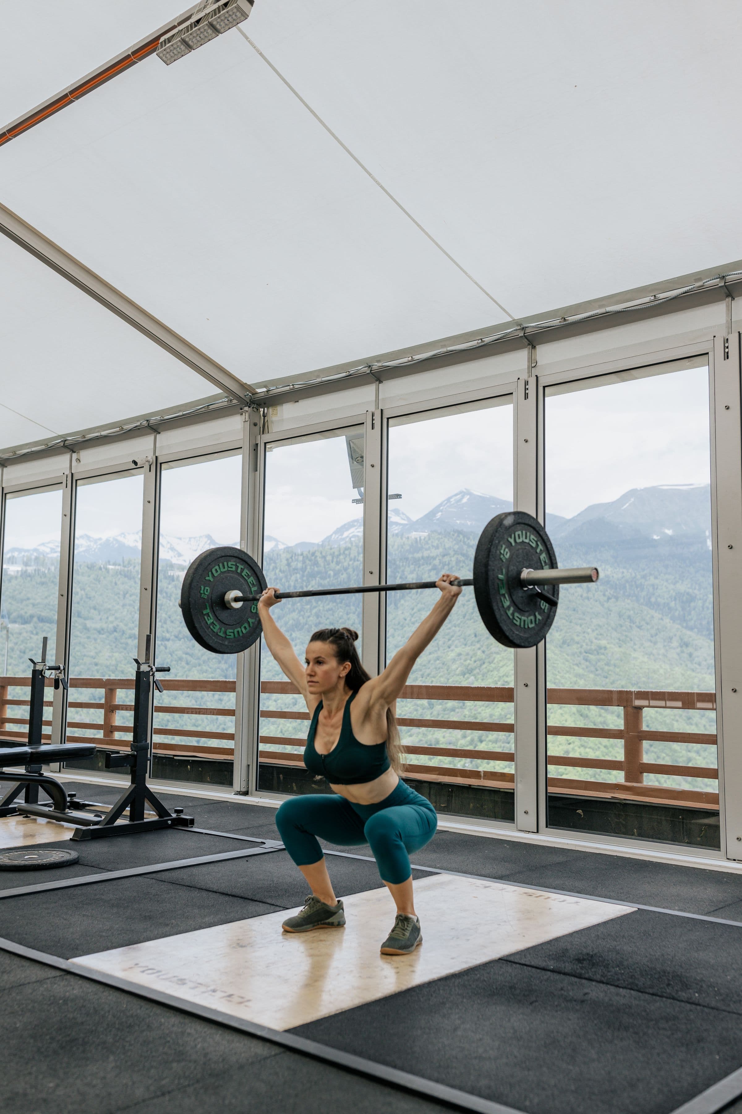 Athlete lifting a barbell in a bright strength-training space