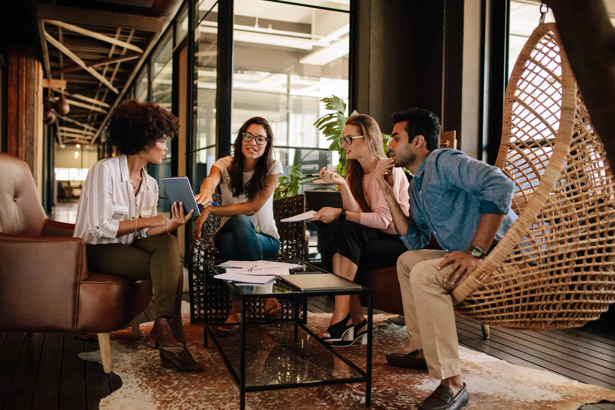 Four people reviewing information together around a tablet
