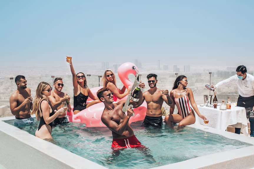 Guests gathering around a rooftop pool at a premium leisure destination