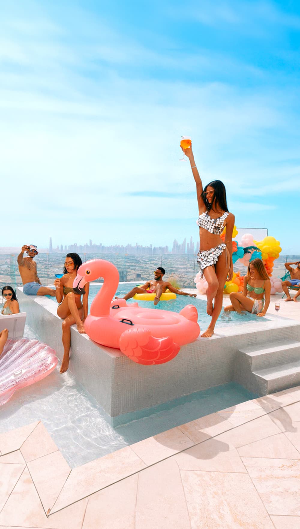 Friends celebrating together at a rooftop pool overlooking the city